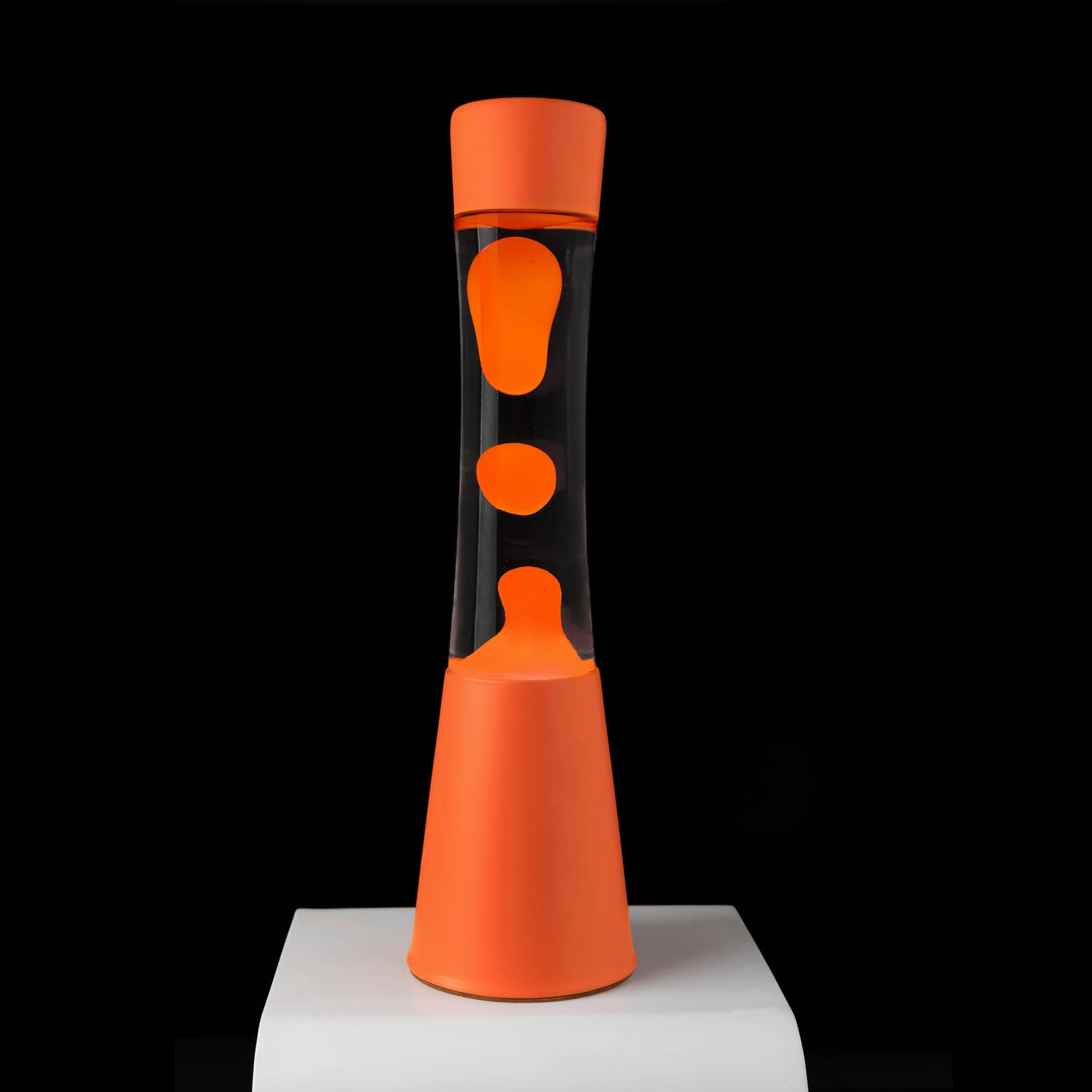 Fisura – Lampa z lawą pomarańczowa. Podstawa i lawa w kolorze pomarańczowym z przezroczystym płynem. Lampa relaksacyjna z zapasową żarówką. 11 cm x 11 cm x 39,5 cm.