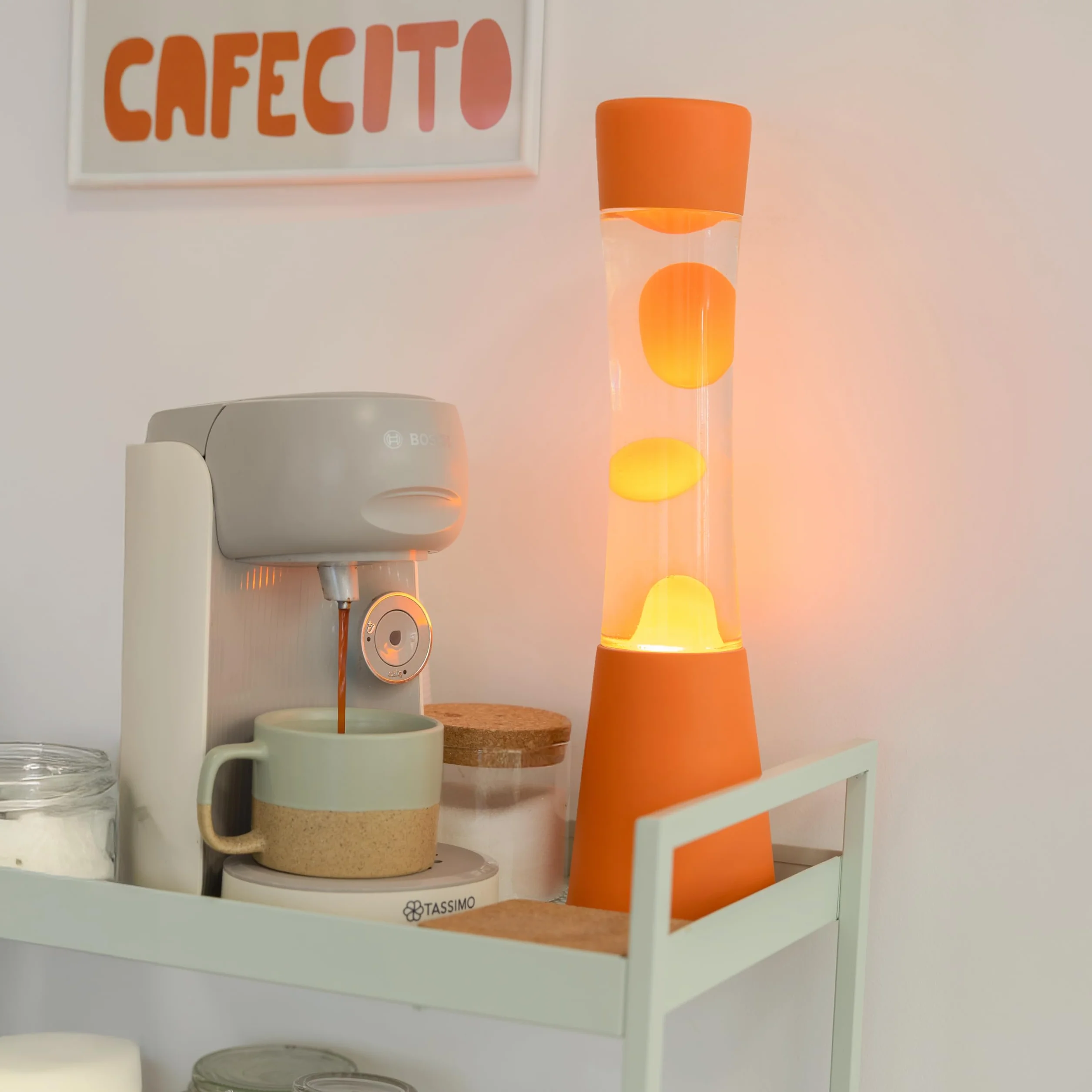 Fisura – Lampa z lawą pomarańczowa. Podstawa i lawa w kolorze pomarańczowym z przezroczystym płynem. Lampa relaksacyjna z zapasową żarówką. 11 cm x 11 cm x 39,5 cm.