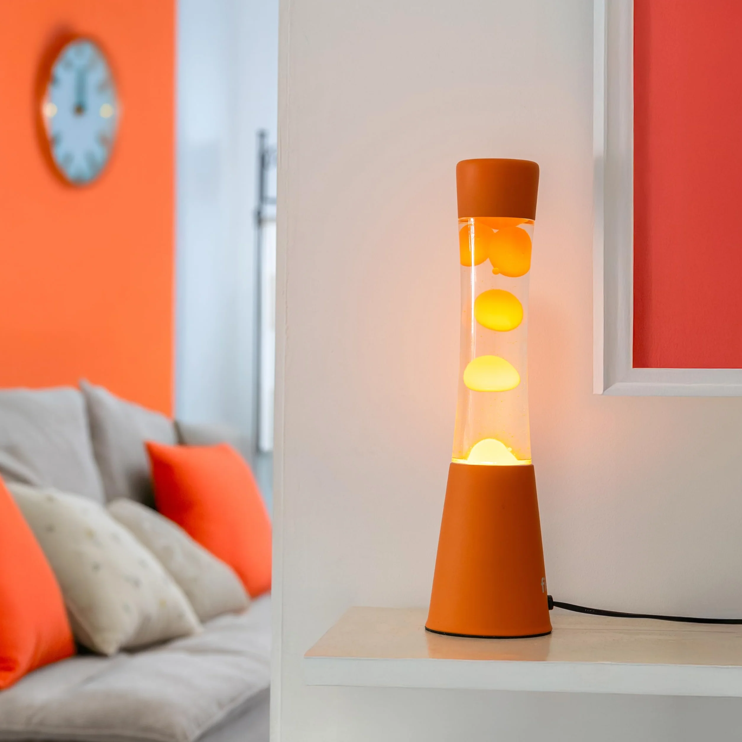 Fisura – Lampa z lawą pomarańczowa. Podstawa i lawa w kolorze pomarańczowym z przezroczystym płynem. Lampa relaksacyjna z zapasową żarówką. 11 cm x 11 cm x 39,5 cm.