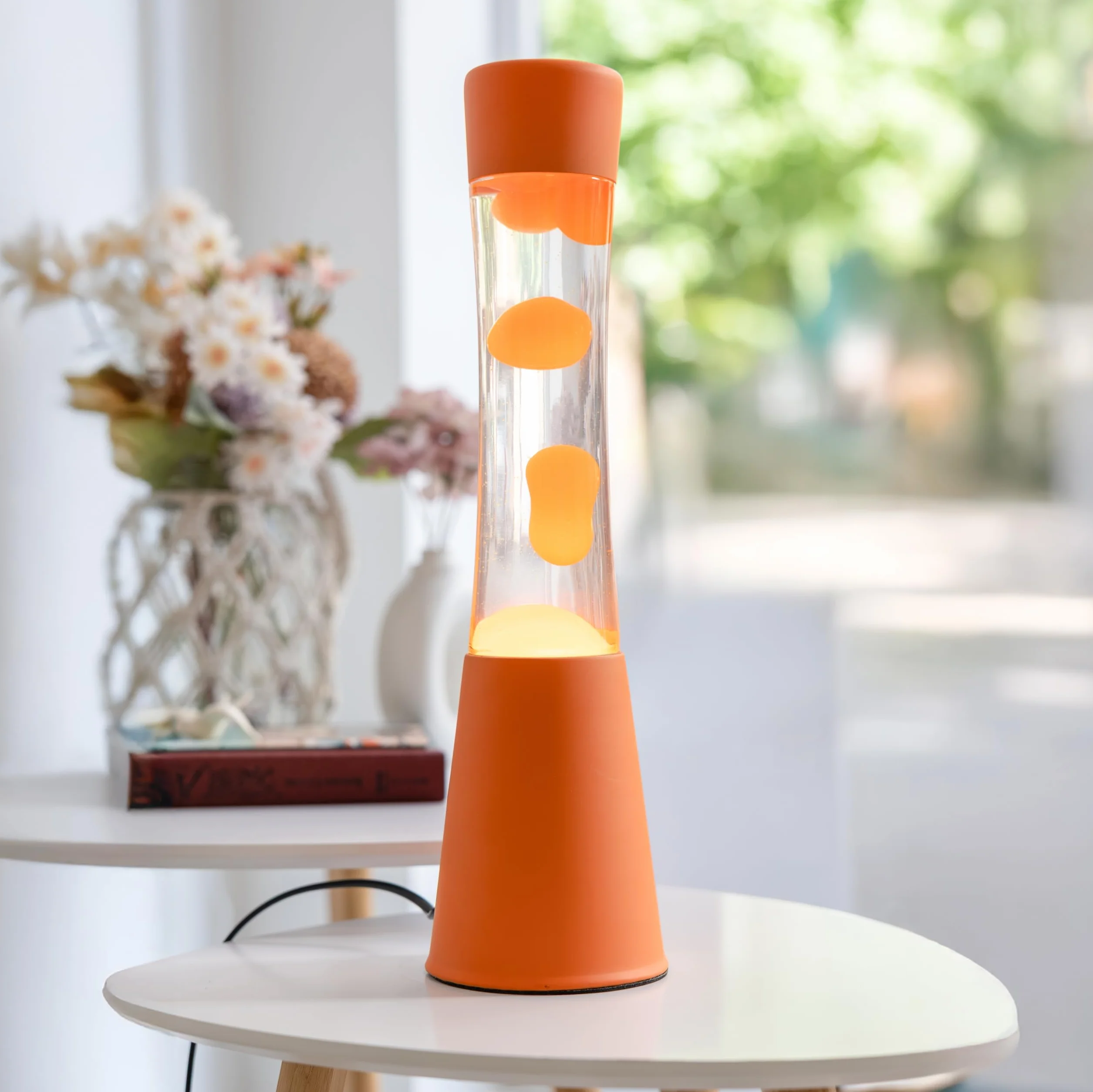 Fisura – Lampa z lawą pomarańczowa. Podstawa i lawa w kolorze pomarańczowym z przezroczystym płynem. Lampa relaksacyjna z zapasową żarówką. 11 cm x 11 cm x 39,5 cm.